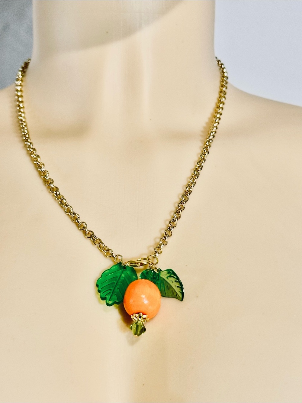 Gold-Tone Necklace with Orange Fruit Pendant and Green Leaf Accents